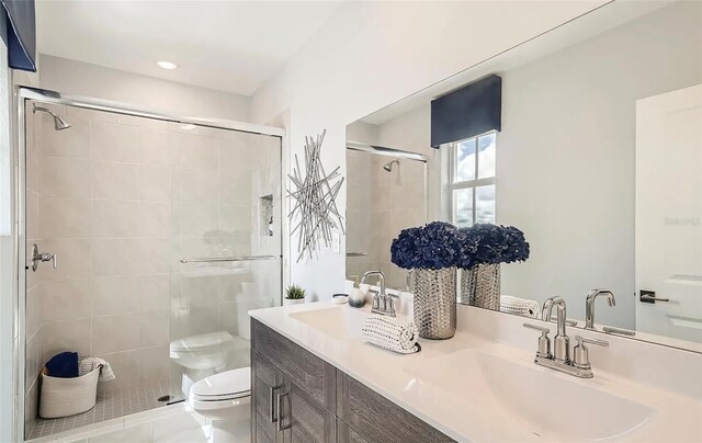 bathroom with tile patterned floors, vanity, an enclosed shower, and toilet