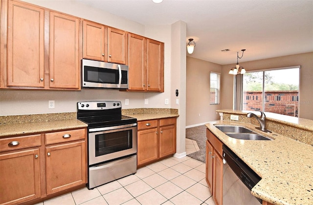 kitchen with sink, decorative light fixtures, appliances with stainless steel finishes, a notable chandelier, and light tile patterned flooring