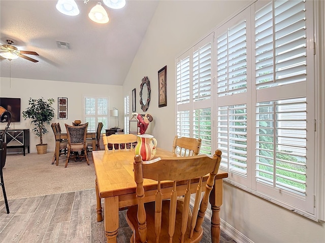 dining space with vaulted ceiling, plenty of natural light, hardwood / wood-style floors, and ceiling fan