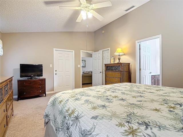 bedroom with lofted ceiling, ceiling fan, connected bathroom, a textured ceiling, and light colored carpet