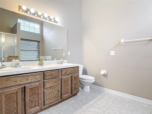 bathroom featuring tile patterned flooring, vanity, toilet, and walk in shower