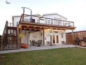 back of house featuring a patio, a deck, and a lawn