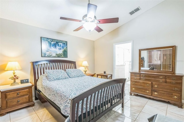 bedroom with ceiling fan, vaulted ceiling, light tile patterned floors, and ensuite bath