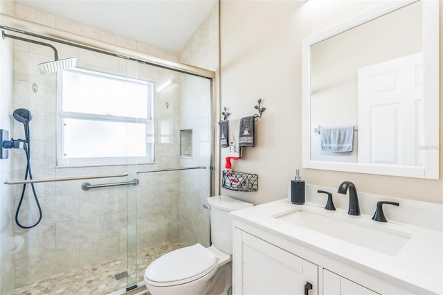 bathroom with vanity, toilet, and a shower with shower door