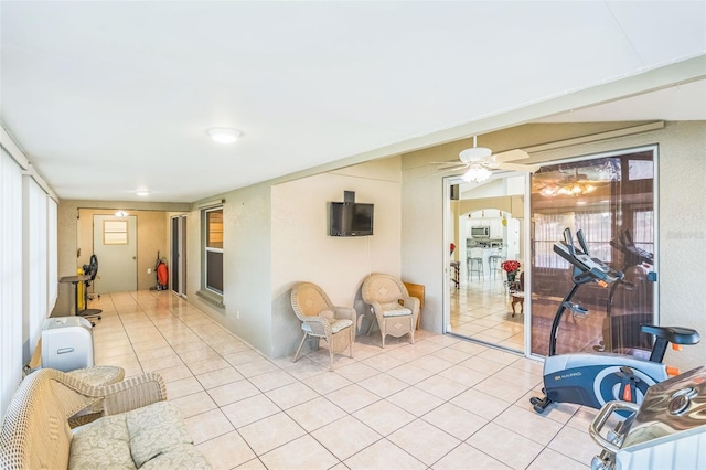 workout room with light tile patterned floors and ceiling fan