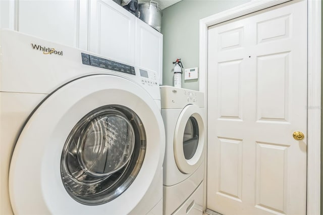 clothes washing area featuring cabinets and independent washer and dryer