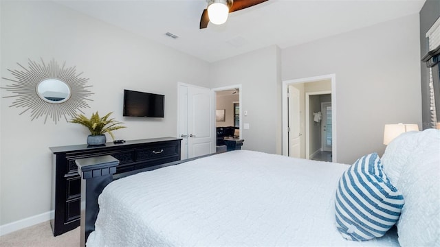 carpeted bedroom with ensuite bath and ceiling fan