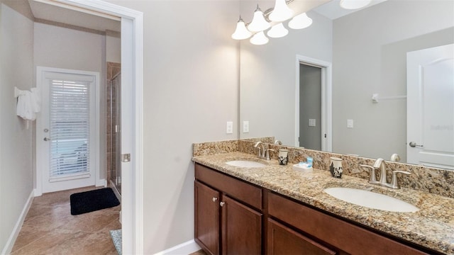 bathroom featuring tile patterned flooring, a shower with door, vanity, and a notable chandelier