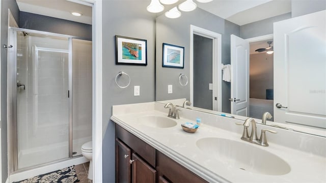 bathroom with tile patterned floors, vanity, ceiling fan, toilet, and a shower with shower door