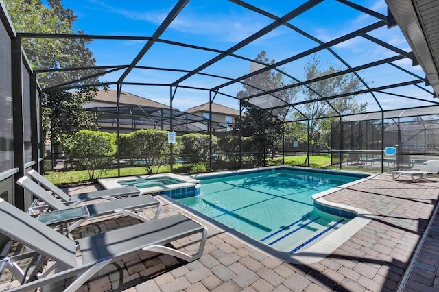 view of swimming pool with glass enclosure, an in ground hot tub, and a patio