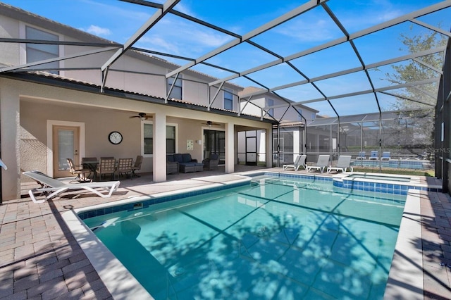 view of pool featuring a lanai, ceiling fan, a patio, and an outdoor living space