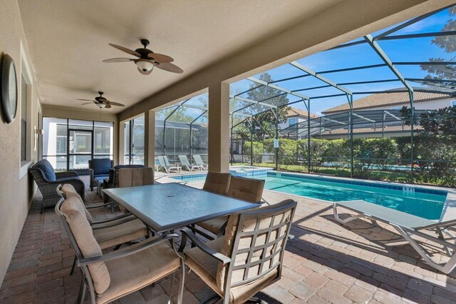 view of swimming pool featuring a patio, ceiling fan, and a lanai