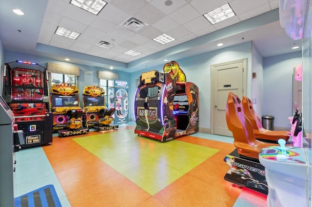 recreation room featuring a drop ceiling and a tray ceiling