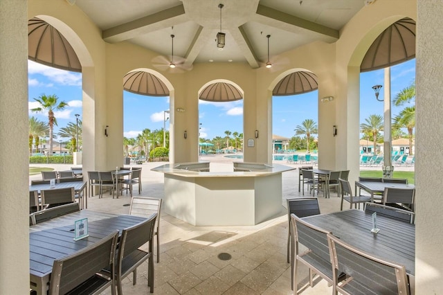 view of patio / terrace with ceiling fan, a community pool, and an outdoor bar