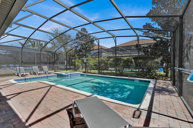 view of pool featuring glass enclosure, a patio area, and an in ground hot tub