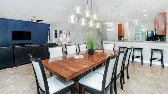 dining space featuring ceiling fan and sink