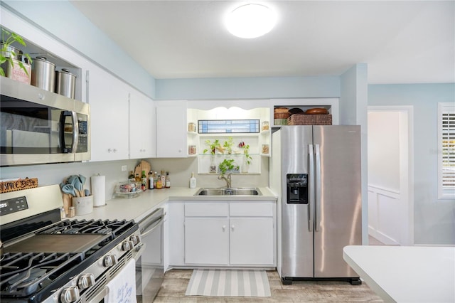 kitchen with sink, white cabinetry, and stainless steel appliances