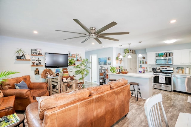 living room with light hardwood / wood-style floors and ceiling fan