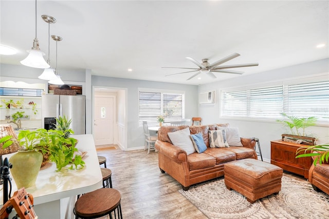 living room with ceiling fan and light hardwood / wood-style flooring