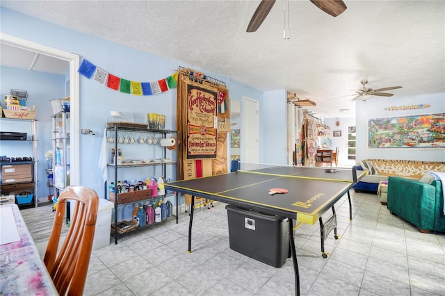 playroom with ceiling fan and a textured ceiling