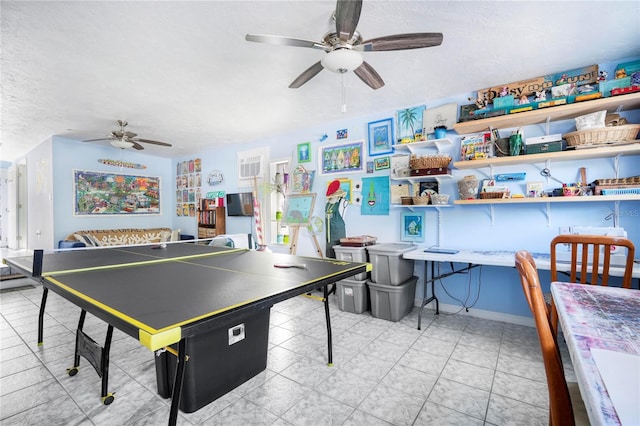 playroom featuring ceiling fan and a textured ceiling