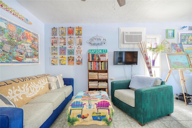 interior space with tile patterned floors, ceiling fan, a textured ceiling, and a wall mounted air conditioner