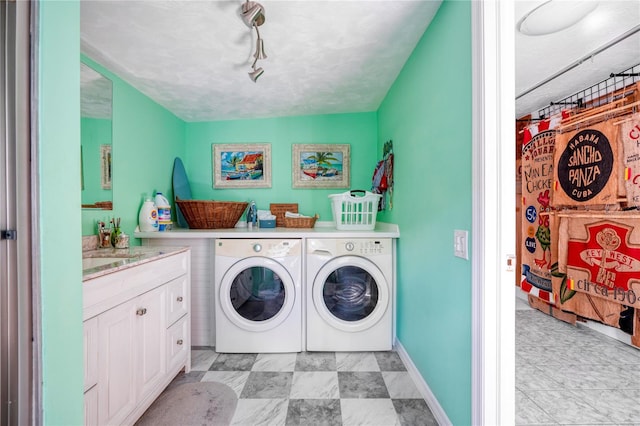 clothes washing area featuring washer and clothes dryer, track lighting, and sink