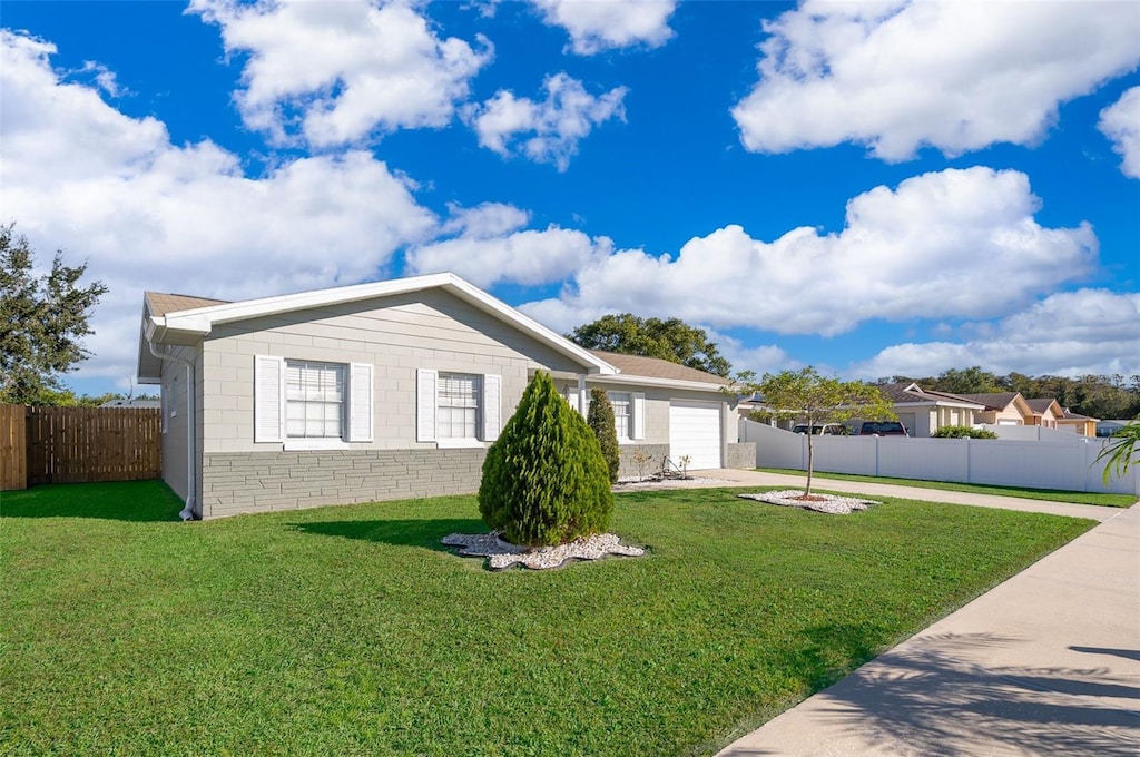 single story home with a garage and a front lawn