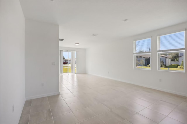 unfurnished room with plenty of natural light and light tile patterned flooring