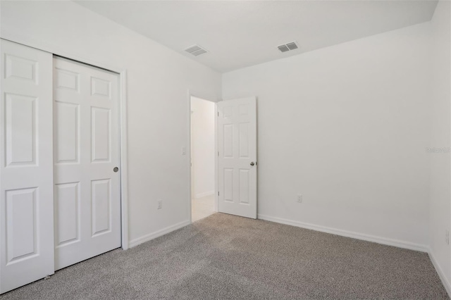 unfurnished bedroom featuring carpet floors and a closet