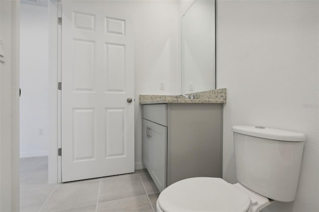 bathroom with tile patterned flooring, vanity, and toilet