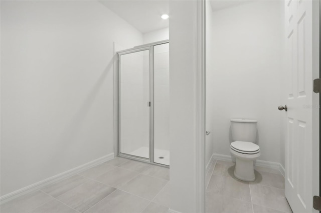 bathroom featuring tile patterned flooring, toilet, and walk in shower