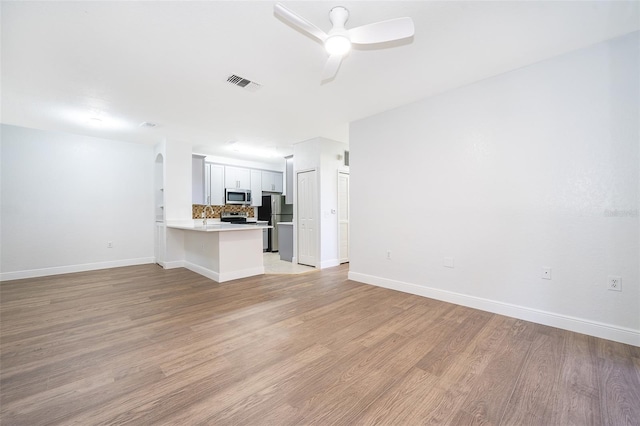 unfurnished living room with light hardwood / wood-style flooring and ceiling fan