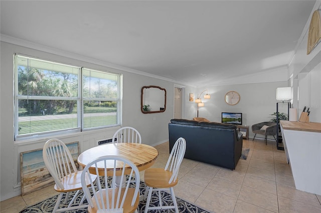 tiled dining space featuring lofted ceiling and crown molding