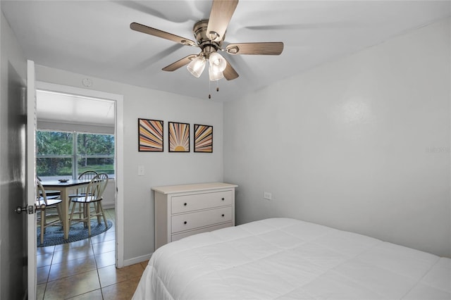 tiled bedroom featuring ceiling fan