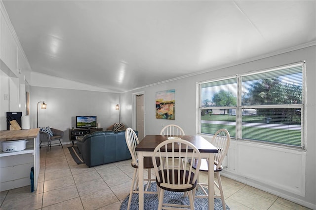 dining room with light tile patterned floors, crown molding, and vaulted ceiling