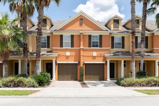 875 Assembly Ct, Reunion, FL 34747 - townhome / multi-family property with driveway, stucco siding, a garage, and roof with shingles