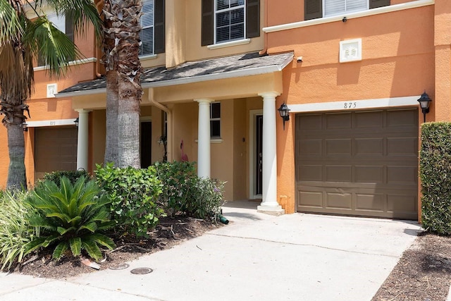 875 Assembly Ct, Reunion, FL 34747 - view of exterior entry featuring an attached garage, stucco siding, and driveway