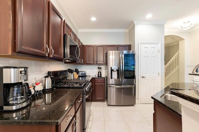 kitchen featuring decorative backsplash, ornamental molding, stainless steel appliances, and dark stone counters