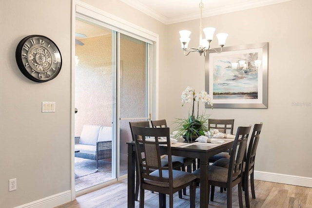 dining room with light hardwood / wood-style floors, crown molding, and a notable chandelier