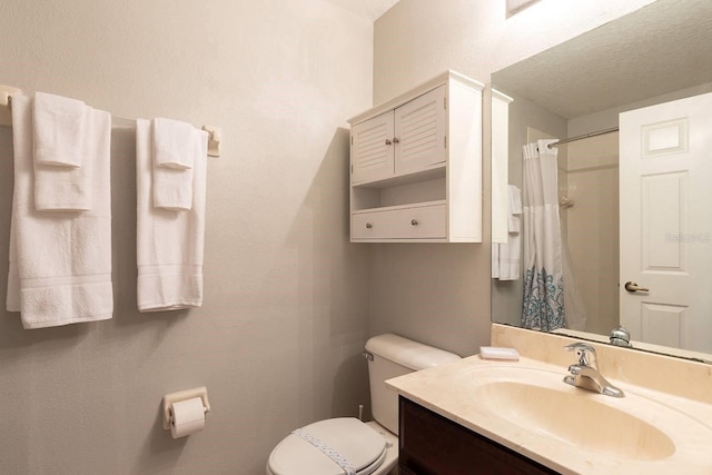 bathroom with vanity, a textured ceiling, toilet, and curtained shower