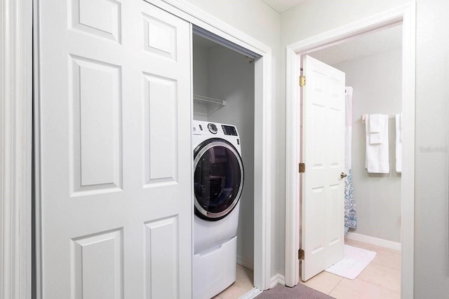 washroom with light tile patterned flooring and washer / dryer