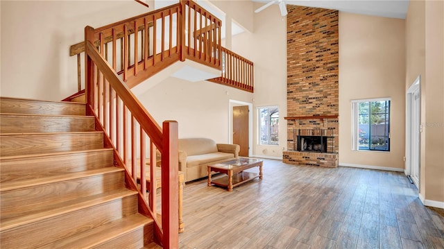 living room featuring a towering ceiling, hardwood / wood-style floors, and a fireplace