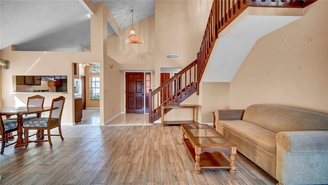 entrance foyer with hardwood / wood-style flooring and high vaulted ceiling