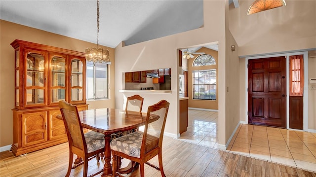 dining space featuring an inviting chandelier, light hardwood / wood-style floors, and vaulted ceiling