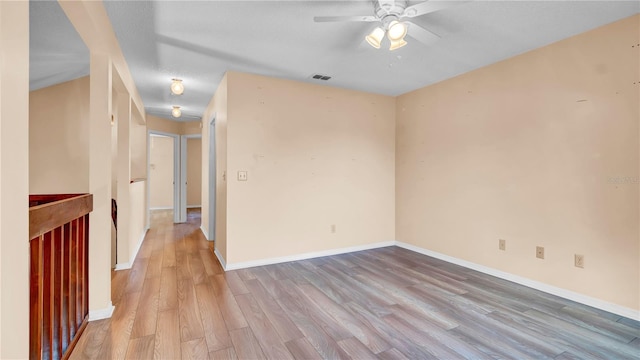 spare room with ceiling fan and light wood-type flooring