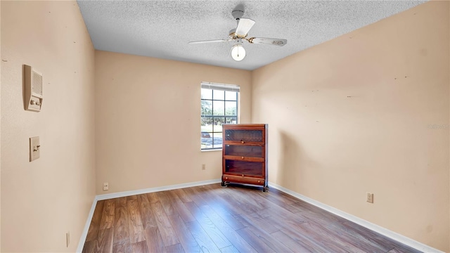 empty room featuring a textured ceiling, ceiling fan, and light wood-type flooring