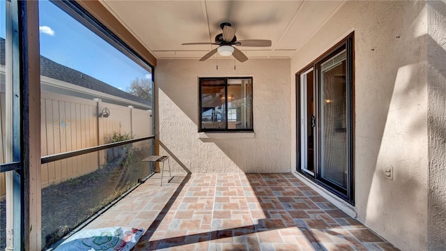 unfurnished sunroom with ceiling fan