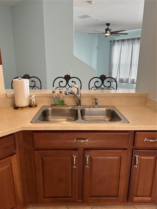 kitchen with a textured ceiling, kitchen peninsula, and sink