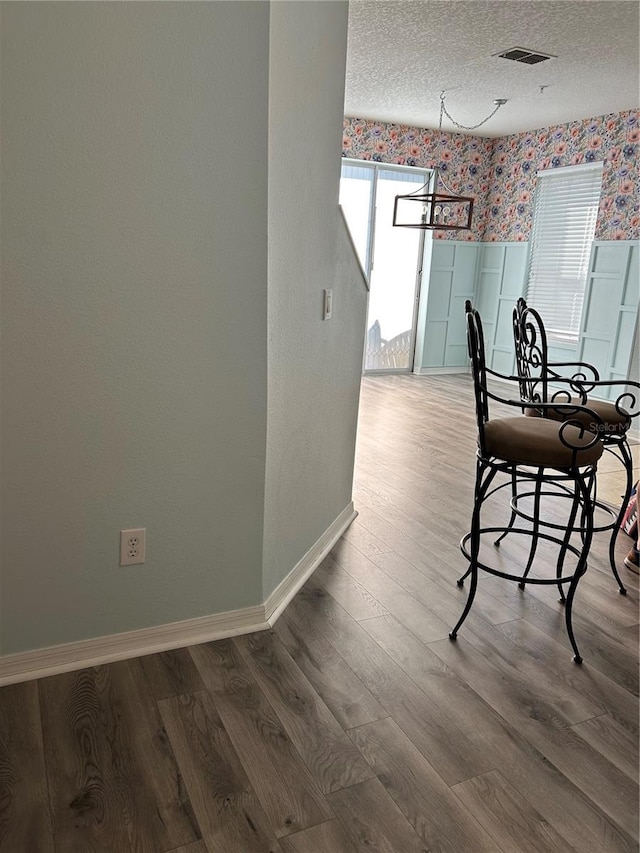 3031 San Jacinto Cir Unit 3031, Sanford, FL 32771 - dining space featuring wallpapered walls, wainscoting, wood finished floors, a textured ceiling, and baseboards